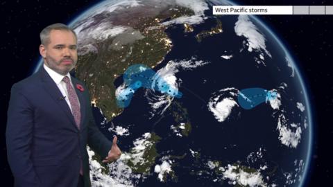 Ben Rich stands in front of a weather map of the west Pacific