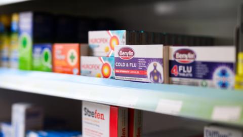 Boxes of Benylin cold and flu medication are seen on the shelves of a pharmacy.