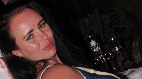 Saffron Cole-Nottage with long dark hair looking at the camera. She is wearing a striped top.