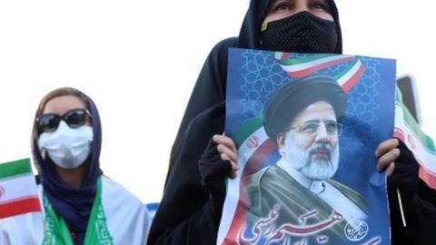 Supporter holds a poster of Ebrahim Raisi (11/06/21)