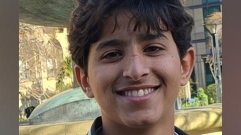 Abdullah Yaser Abdullah Taleb smiles at the camera. He has short, dark hair