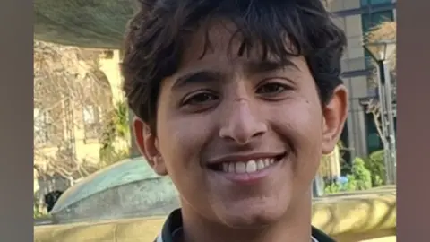 Abdullah Yaser Abdullah Taleb smiles at the camera. He has short, dark hair