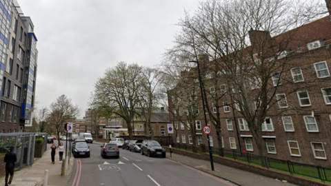 A Google image of New Park Road, a residential street with 20mph speed limit signs, cars parked on either side of the road and flats on each side.