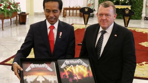 President Joko Widodo shows off the Metallica album from Danish Prime Minister Lars Rasmussen