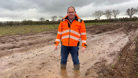 Jon Hammond standing in a muddy field