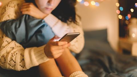 File photo: Girl texting on smartphone at home