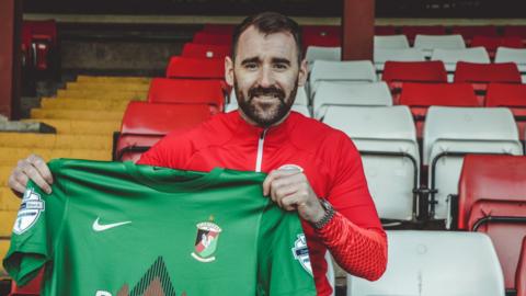 Niall McGinn poses with the Glentoran shirt