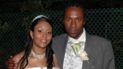 Riccardo Holness with his sister Ramona Marsh, who is wearing a white wedding dress. Mr Holness is wearing a grey suit.