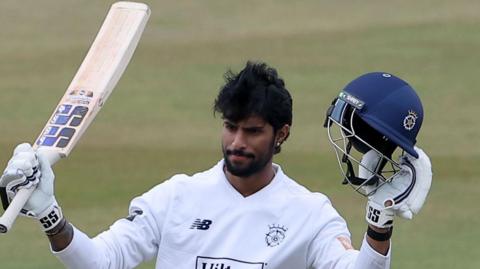 Tilak Varma raises his bat and helmet to the crowd