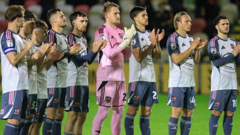 Exeter City players applaud their fans