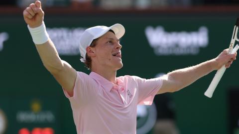 Jannik Sinner raises his arms in celebration after winning the Indian Wells title