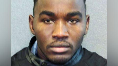 Headshot of Badreddin Abdalla Adam Bosh - a man with short, dark, hair and a short beard, looking straight into the camera.