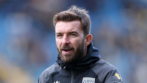 West Brom interim manager James Morrison headshot looking positive in club waterproof jacketve