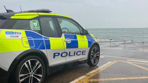 A Jersey police car facing out onto the ocean at Greve de Lecq in Jersey