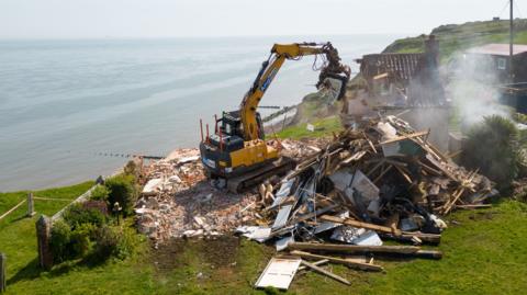 Plant destroying a farmhouse which is has almost been fully demolished