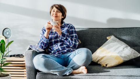 Woman drinking tea on a sofa