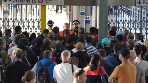 Passengers wait for Stratford station to open in London