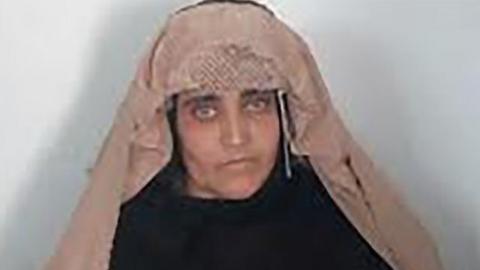 In this handout photograph released by Pakistan"s Federal Investigation Agency (FIA) on October 26, 2016, Afghan Sharbat Gula, the "Afghan Girl" who appeared on the cover of a 1985 edition of National Geographic magazine, waits ahead of a court hearing in Peshawar