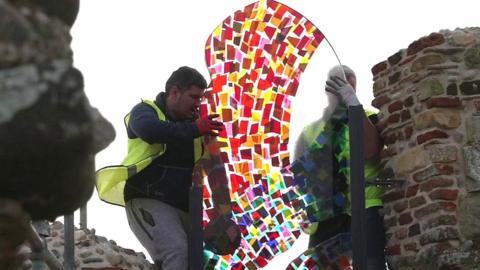 Stained-glass window being installed