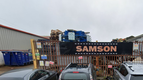 Streetview of premises with lots of objects and crates outside.
