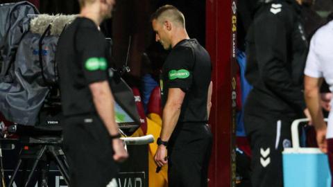 Referee Steven McLean checks for a potential penalty for Hearts against Motherwell