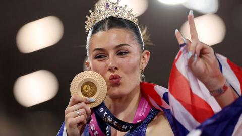 Gold medalist Amy Hunt of Team Great Britain poses for a photo with her medal, tiara and national flag after victory in the Women's 200m Final