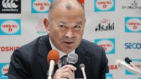 Eddie Jones speaks into a microphone