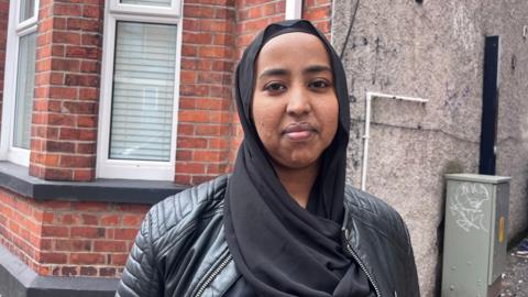 Ifrah looking at the camera. She is wearing a black leather jacket.
