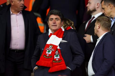 Southampton FC owner Dragan Solak looks straight ahead. He is wearing a red and white Southampton scarf.