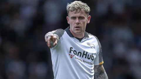 Sammie Szmodics wearing a white Derby shirt points forward