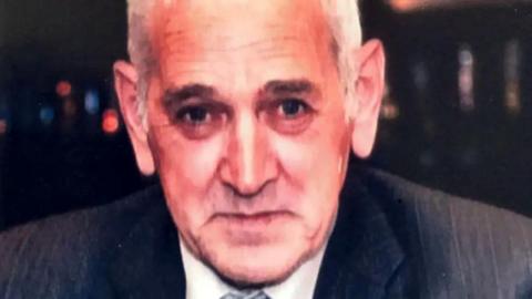 Robert Garvock, a 68-year-old man with grey hair and wearing a suit, smiling at the camera.