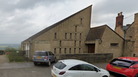 Sloped roof on a church building with hills in the background