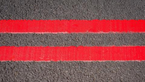 Two striking red lines on the side of a road. 