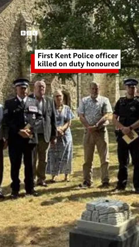 People standing by grave