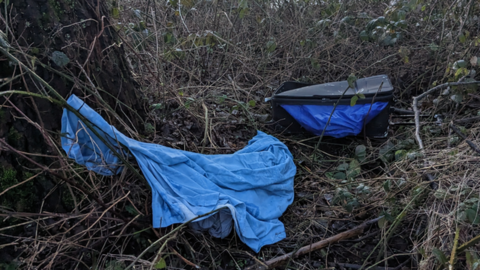 The suitcase had been dumped behind a tree