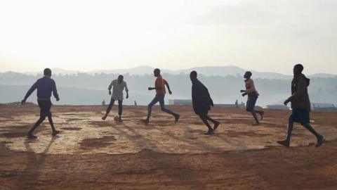 Boys play football at an camp for displaced people