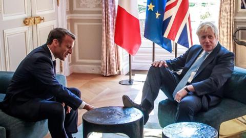 UK PM Boris Johnson, making a joke with his foot on the table at a meeting with President Macron