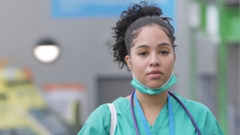 Stock photo of a doctor in scrubs leaving a hospital