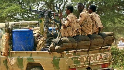 An archive shot of three RSF fighters on the back of an machine-gun armed Toyota pick-up truck in Darfur 