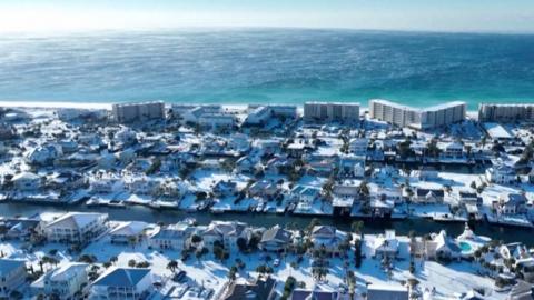 Beach holiday peninsula covered in snow, shown on still from drone video