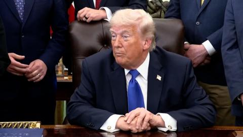 President Donald Trump, looking at reporters