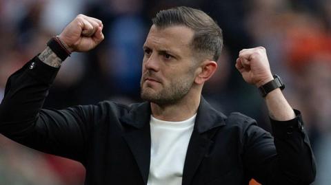 Jack Wilshere lifts his fists in celebration during a Luton Town match