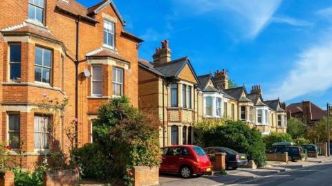 A row of large houses on an Oxford street. The nearest to the camera has three storeys.