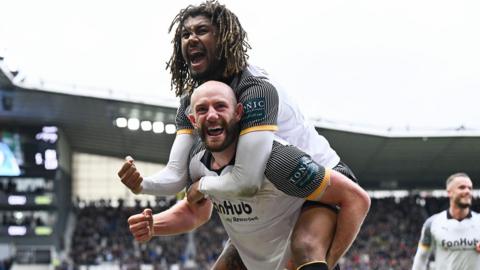 Derby's Dion Sanderson jumps on the back of goalscorer Matt Clarke