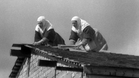 Two Carmelite nuns repairing a roof.