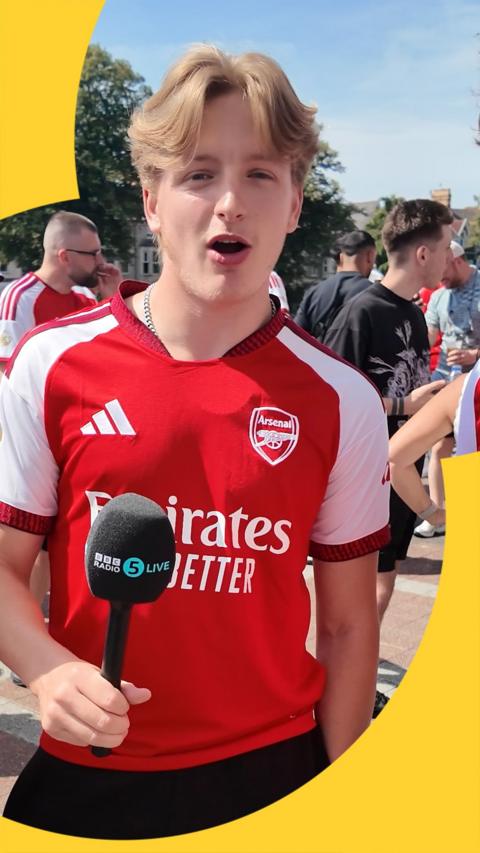 Arsenal fan is being interviewed with a BBC 5 Live microphone as he gives his opinion on the new signings