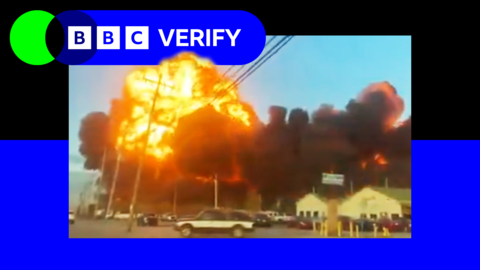 A fireball erupts after the UPS cargo jet crash in Louisville, Kentucky. In the foreground cars are driving along a highway as the blast rages.