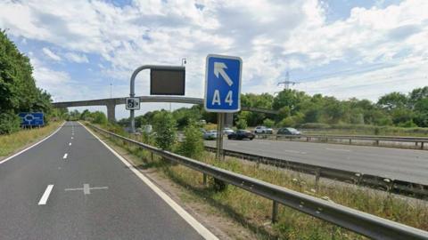 M4 motorway eastbound near Theale with slip road leading off to the A4.  It is a bright, sunny day.