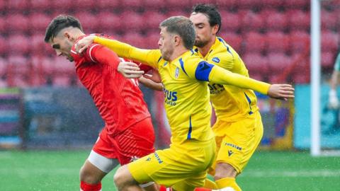 Sean Graham and Lyndon Kane vie for possession at Inver Park