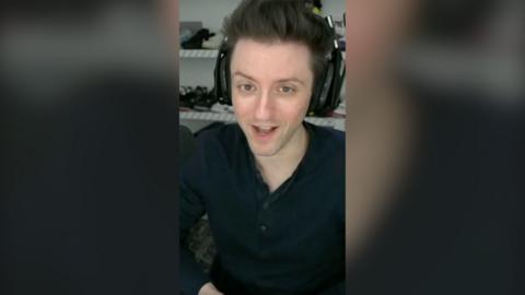 YouTube streamer Datto wearing a black shirt and gaming headphones.